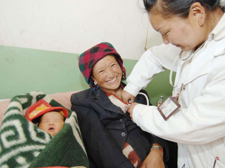 A woman (L) receives medical checkup at a hospital in Dagze County, southwest China's Tibet Autonomous Region, on April 9, 2007.