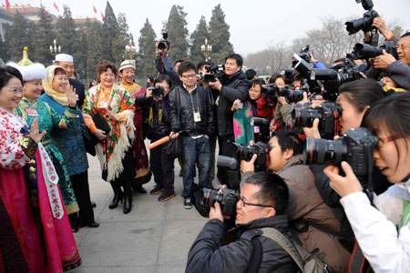 Journalists take photos of the members of the 11th National Committee of the Chinese People's Political Consultative Conference (CPPCC) outside the Great Hall of the People in Beijing, capital of China, March 3, 2009. The Second Session of the 11th CPPCC National Committee opens on Tuesday. 