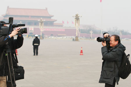 A photojournalist works at Tian'anmen Square in Beijing, capital of China, on March 3, 2009. 