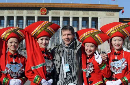 Attendants take photos with a foreigner outside the Great Hall of the People in Beijing, capital of China, on March 5, 2009. The Second Session of the 11th National People's Congress (NPC) opened on Thursday.