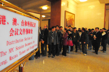 Journalists queue to get the documents of the Second Session of the 11th National People's Congress (NPC) before the opening of the session at the Great Hall of the People in Beijing, capital of China, on March 5, 2009. The Second Session of the 11th NPC is to open on Thursday. 