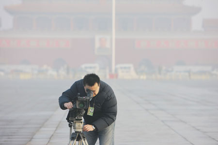 A journalist works before the opening of the Second Session of the 11th National People's Congress (NPC) at Tian'anmen Square in Beijing, capital of China, on March 5, 2009. 