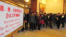 Journalists queue to get the documents of the Second Session of the 11th National People's Congress (NPC) before the opening of the session at the Great Hall of the People in Beijing, capital of China, on March 5, 2009. The Second Session of the 11th NPC is to open on Thursday.