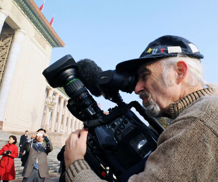 A foreign journalist works outside the Great Hall of the People in Beijing, capital of China, March 5, 2009. The Second Session of the 11th National People's Congress (NPC) opens on Thursday. 