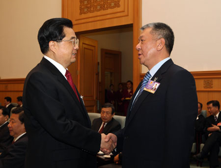 Chinese President Hu Jintao (L) shakes hands with Edmund Ho Hau Wah, chief executive of China's Macao Special Administrative Region, prior to the opening meeting of the Second Session of the 11th National People's Congress (NPC) at the Great Hall of the People in Beijing, capital of China, on March 5, 2009. 