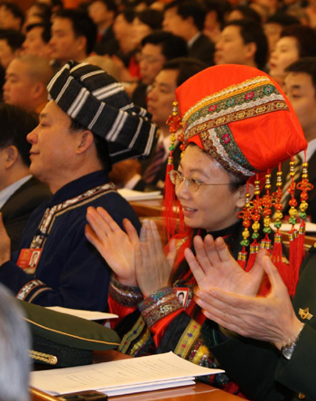 Delegates wearing traditional costumes applaud at the Second Session of the 11th National People's Congress at the Great Hall of the People in Beijing on March 5, 2009.