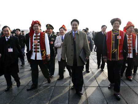 Deputies in traditional costumes walk into the Great Hall of the People to attend the opening of the Second Session of the 11th National People's Congress in Beijing, on March 5, 2009. 