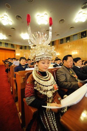 A delegate wearing a traditional costume reads a copy of the government work report at the opening of the Second Session of the 11th National People's Congress at the Great Hall of the People in Beijing on March 5, 2009. 