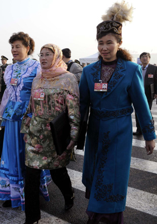 Deputies dressed in traditional costumes walk into the Great Hall of the People to attend the opening meeting of the Second Session of the 11th National People's Congress in Beijing, on March 5, 2009. 