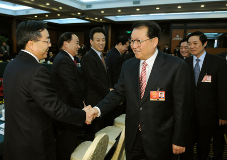 Li Changchun (front R), member of the Standing Committee of the Political Bureau of the Communist Party of China (CPC) Central Committee, shakes hands with a deputy to the Second Session of the 11th National People's Congress (NPC) from southwest China's Sichuan Province, in Beijing, capital of China, on March 5, 2009. Li Changchun joined in the panel discussion of Sichuan delegation on the opening day of the Second Session of the 11th NPC. 