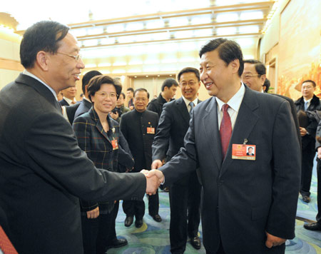 Chinese Vice President Xi Jinping (front R), who is also a member of the Standing Committee of the Political Bureau of the Communist Party of China (CPC) Central Committee, shakes hands with a deputy to the Second Session of the 11th National People's Congress (NPC) from east China's Shanghai municipality, in Beijing, capital of China, on March 5, 2009. Xi Jinping joined in the panel discussion of Shanghai delegation on the opening day of the Second Session of the 11th NPC.