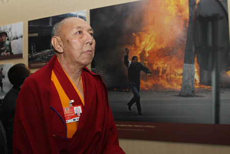 A member of the 11th National Committee of the Chinese People's Political Consultative Conference (CPPCC) from southwest China's Tibet Autonomous Region, who is attending the Second Session of the 11th National Committee of the CPPCC, visits an exhibition titled Democratic Reform in the Tibet Autonomous Region at the Cultural Palace of Nationalities in Beijing, capital of China, on March 11, 2009. 