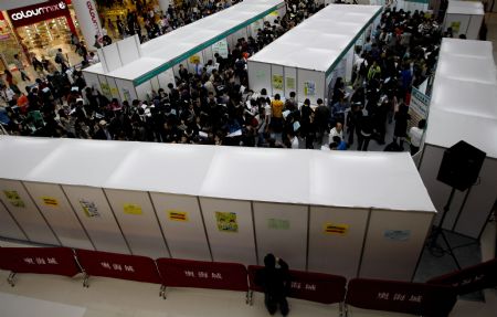 Job hunters check job information during a job fair in Hong Kong, south China, on March 11, 2009. The job fair was held by the Labour Department of the Hong Kong SAR Government, offering more than 7,000 vacancies in 80 firms. 