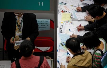 A Job hunter hands in application to employer during a job fair in Hong Kong, south China, on March 11, 2009. 