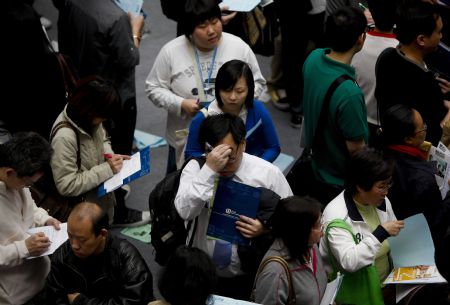 Job hunters check job information during a job fair in Hong Kong, south China, on March 11, 2009. 