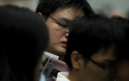 Job hunters check job information during a job fair in Hong Kong, south China, on March 11, 2009. The job fair was held by the Labour Department of the Hong Kong SAR Government, offering more than 7,000 vacancies in 80 firms.