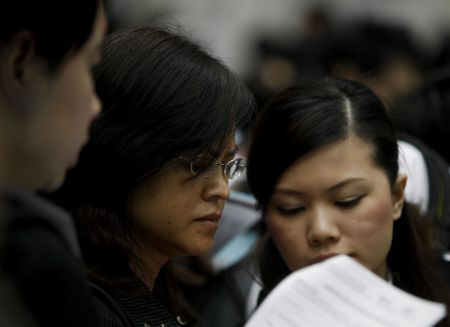 Job hunters check job information during a job fair in Hong Kong, south China, on March 11, 2009. 