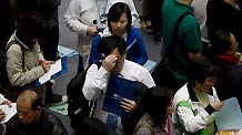 Job hunters check job information during a job fair in Hong Kong, south China, on March 11, 2009. The job fair was held by the Labour Department of the Hong Kong SAR Government, offering more than 7,000 vacancies in 80 firms.