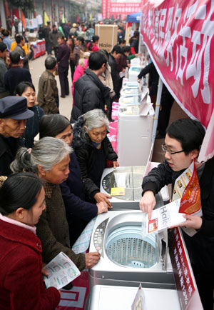 Rural residents in hustle and bustle pick out arrays of washing machines on sales with governmental subsidies, at the trade fair tour for sales promotion of home appliances to countryside, at Yanghe Township, Huaying City, southwest China's Sichuan Province, on March 11, 2009. 