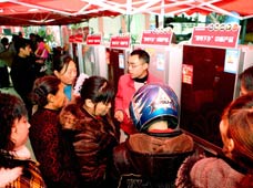 Rural residents in hustle and bustle pick out arrays of refrigerators on sales with governmental subsidies at the trade fair tour for sales promotion of home appliances to countryside, at Yanghe Township, Huaying City, southwest China's Sichuan Province, on March 11, 2009.
