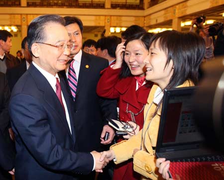 Chinese Premier Wen Jiabao (L) shakes hands with a journalist after his meeting with the press at the Great Hall of the People in Beijing, capital of China, on March 13, 2009. The annual National People's Congress (NPC) session closed on Friday.