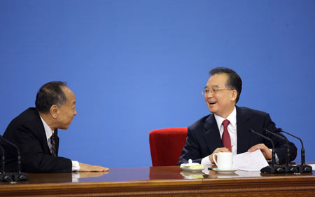 Chinese Premier Wen Jiabao (R) talks with Li Zhaoxing, spokesman for the Second Session of the 11th National People's Congress (NPC), during a press conference after the closing meeting of the Second Session of the 11th NPC at the Great Hall of the People in Beijing, capital of China, on March 13, 2009. The annual NPC session closed on Friday. 