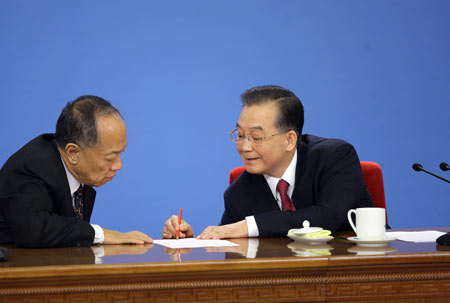 Chinese Premier Wen Jiabao (R) talks with Li Zhaoxing, spokesman for the Second Session of the 11th National People's Congress (NPC), during a press conference after the closing meeting of the Second Session of the 11th NPC at the Great Hall of the People in Beijing, capital of China, on March 13, 2009. The annual NPC session closed on Friday.