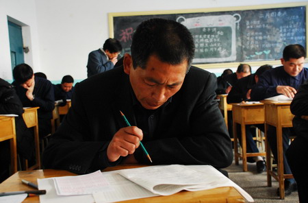 A village cadre writes the civil servant exam in Dongying city in east China's Shandong Province, on March 15, 2009. The province will hire 8,600 civil servants from 390,000 candidates this year, the ratio being about one chosen for every 45 candidates. 