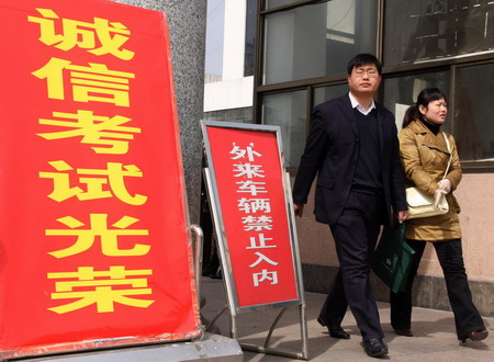 Two people walk out after they finish writing the civil service examination in Zaozhuang city in east China's Shandong Province, on March 15, 2009. The province will hire 8,600 civil servants from 390,000 candidates this year, the ratio being about one chosen for every 45 candidates. 