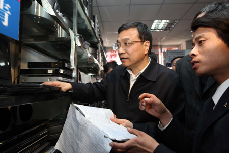 Chinese Vice Premier Li Keqiang (L) talks with a salesman about the process of bringing home appliances to the countryside in a market of Yan'an, a city of northwest China's Shaanxi Province, on March 17, 2009. Li Keqiang made an inspection of Shaanxi Province recently. 