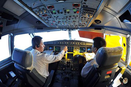 Photo taken on March 18 shows two pilots in the cockpit of the air bus A330-300 on its high-precision-navigation test flight. 