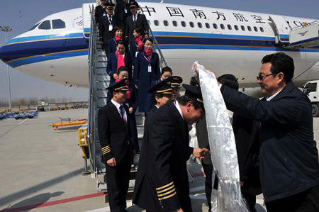 Photo taken on March 18 shows the crew of the air bus A330-300 receiving hada after its test flight. 