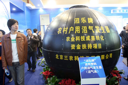 Visitors view a marsh gas generator during the China International Energy Saving, Emission Reduction and New Energy Science and Technology Expo at the Beijing Exhibition Center in Beijing, capital of China, on March 22, 2009.