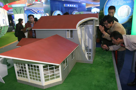Visitors views an ecological farm house model featuring earthquake resistance and energy saving during the China International Energy Saving, Emission Reduction and New Energy Science and Technology Expo at the Beijing Exhibition Center in Beijing, capital of China, on March 22, 2009. 