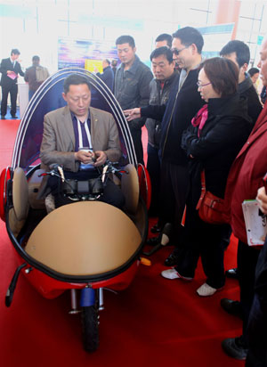 An exhibitor shows an electric vehicle during the China International Energy Saving, Emission Reduction and New Energy Science and Technology Expo at the Beijing Exhibition Center in Beijing, capital of China, on March 22, 2009. More than 200 companies and organizations took part in the five-day expo, opened on March 19. 