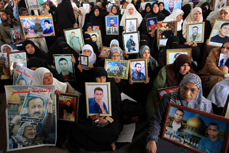 Palestinian women hold the portraits of their jailed relatives during a protest to demand the release of Palestinian prisoners held in Israeli jails, in Gaza City, on March 23, 2009. Israeli officials met with Hamas prisoners over the past few days to discuss a prisoner exchange deal that would secure the release of an Israeli soldier held captive in the Gaza Strip for over 1,000 days, a Palestinian news agency reported Monday. 