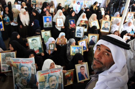 Palestinian women hold the portraits of their jailed relatives during a protest to demand the release of Palestinian prisoners held in Israeli jails, in Gaza City, on March 23, 2009.