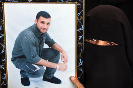 A Palestinian woman holds a portrait of her jailed relative during a protest to demand the release of Palestinian prisoners held in Israeli jails, in Gaza City, on March 23, 2009. 