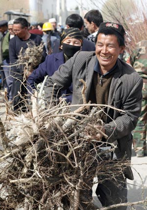 Two residents carry saplings on the bazaar in Hami, northwest China's Xinjiang Uygur Autonomous Region on March 27, 2009. Sapling bazaar of Hami prospered in spring. Saplings such as walnut, peach and jujube were welcomed by consumers.