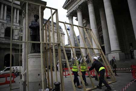 Workers place battens around a war memorial statue outside the building of the Royal Exchange in London on March 31, 2009. The British capital is bracing for protests before and during the summit of the Group of 20 Countries, to be held on April 2. 