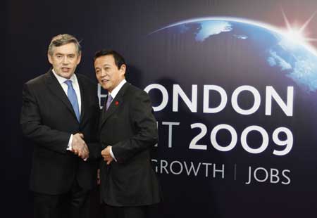 Prime Minister of Japan Taro Aso (R) arrives at ExCel center and is greeted by British Prime Minister Gordon Brown for the summit of the Group of 20 Countries (G20) in London on April 2, 2009. 