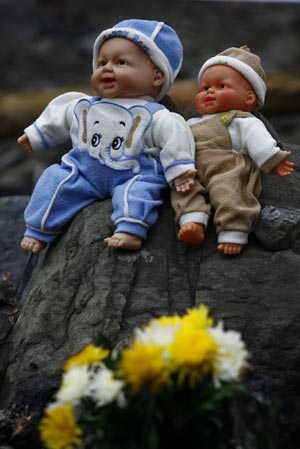 The photo taken on April 2, 2009 shows a couple of dolls placed on a stone by an old lady for her granddaughter died in May 12 Earthquake, in Beichuan, a quake-jolted county of southwest China's Sichuan Province. The ruined city of Beichuan County, once closed to avert pestilence, is opened to the public from April 1 to 4 so that people could offer sacrifices to their deceased relatives and friends in the May 12 Earthquake.