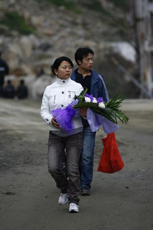 People step into the ruins of Beichuan to mourn over their deceased relatives in May 12 Earthquake, in Beichuan, a quake-jolted county of southwest China's Sichuan Province, on April 2, 2009. The ruined city of Beichuan County, once closed to avert pestilence, is opened to the public from April 1 to 4 so that people could offer sacrifices May 12 Earthquake.