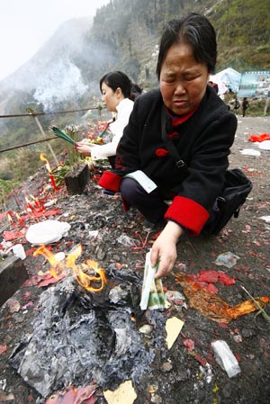 A quake survivor (R) mourns over her deceased relatives in the May 12 Earthquake, in Beichuan, a quake-jolted county of southwest China's Sichuan Province, on April 2, 2009. The ruined city of Beichuan County, once closed to avert pestilence, is opened to the public from April 1 to 4 so that people could offer sacrifices to their deceased relatives and friends in the May 12 Earthquake. 