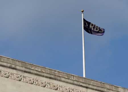 File photo taken on March 24, 2009 shows a flag of the Royal Bank of Scotland (RBS) flying over a building at the financial hub of London, capital of Britain. RBS said on April 7 that it might cut up to 9,000 jobs over the next two years, including 4,500 in the UK, in order to reduce cost. 