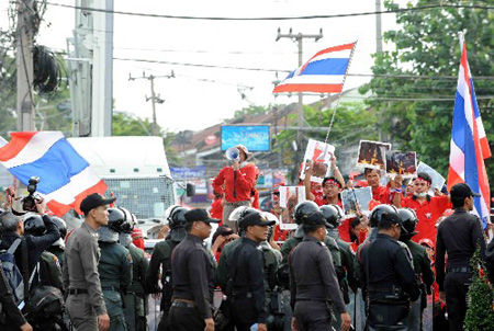 Anti-government protesters confront policemen outside the place where foreign delegations attending the ASEAN related summits are stationed, in Pattaya, Thailand, on April 11, 2009. A scheduled 12th ASEAN-China Summit was not held as scheduled at 9:00 AM on Saturday due to anti-government 'red shirt' blocked all main roads in Pattaya.