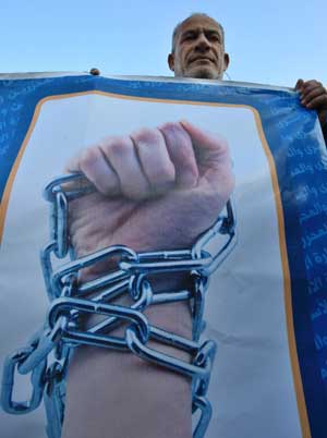 A Palestinian protestor holds a poster during a demonstration calling for the release of Palestinian prisoners in Israeli jails, in Gaza City, on April 16, 2009. 