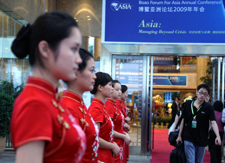 Girls stand ouside the Boao Forum for Asia (BFA) International Conference Center greeting guests attending the BFA Annual Conference 2009 in Boao, south China's Hainan Province, on April 17, 2009. More than 1,600 officials, business leaders, intellectuals and journalists from around the globe gathered here for the three-day conference which kicked off here on Friday. 