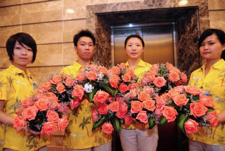 Volunteers holding fresh flowers greet participants from all over the globe attending Boao Forum for Asia (BFA) Annual Conference 2009 in Boao, a scenic town in south China's Hainan Province, on April 19, 2009. Staff members and volunteers provided pleasant services for over 1,600 participants during the three-day BFA Annual Conference 2009 which concluded here on Sunday.