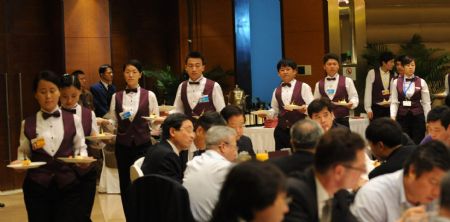 Waiters and waitresses serve at the Luncheon Session of 'Time for a Green New Deal' during Boao Forum for Asia (BFA) Annual Conference 2009 in Boao, a scenic town in south China's Hainan Province, on April 19, 2009. Staff members and volunteers provided pleasant services for over 1,600 participants during the three-day BFA Annual Conference 2009 which concluded here on Sunday. 